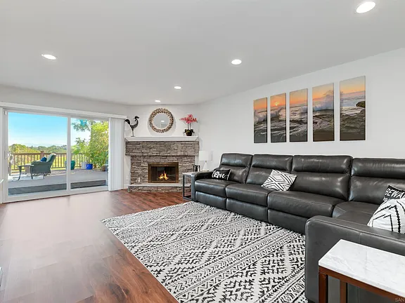 Living room in California house with sofa, rug, fireplace, and sliding door.