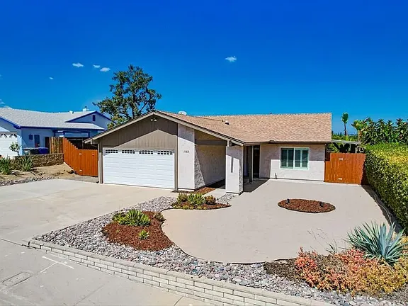 Single-story California house with garage, siding, and landscaped yard.